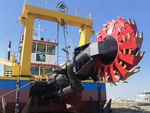 Heavy-duty cutter suction dredger featuring a prominent red rotating cutter head and yellow gantry structure.