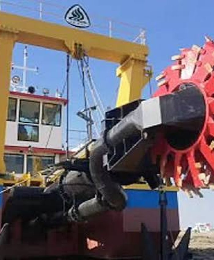 Heavy-duty cutter suction dredger featuring a prominent red rotating cutter head and yellow gantry structure.