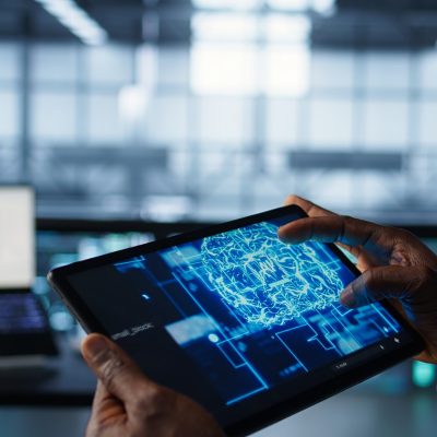 Programmer in data center using AI tech on tablet, testing equipment failover scenarios. Server farm IT specialist uses artificial intelligence on device, ensuring data accessibility, camera B closeup
